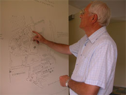 resident looking at old map of the estate drawn onto the wall of the house